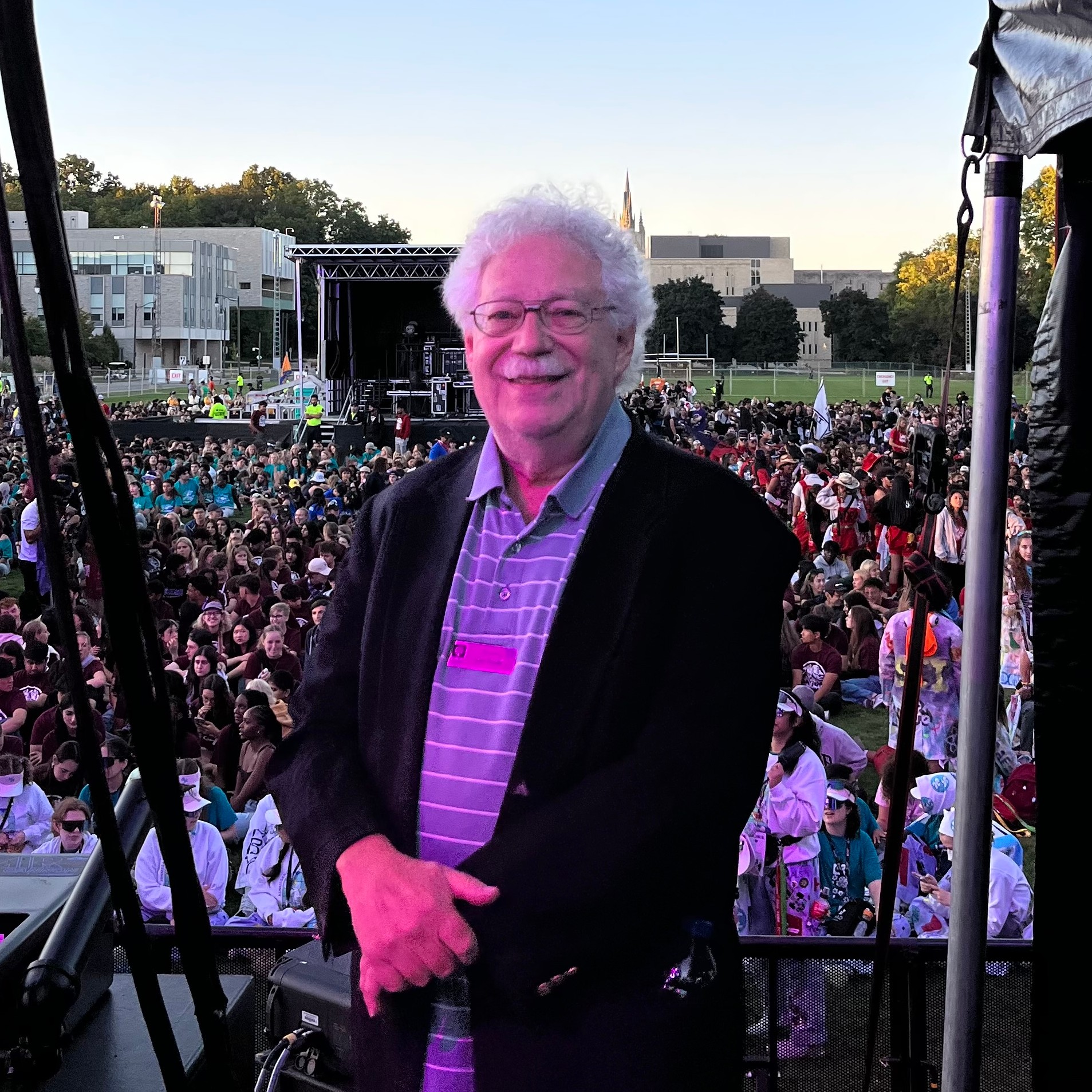 A picture of Sam standing on a stage, in front of a large crowd.